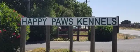 The Happy Paws Kennels road sign on Midway Road